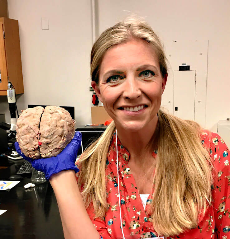 Liesl in a lab holding a model of a brain